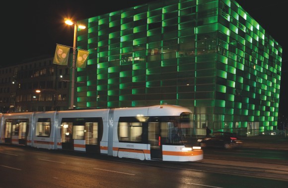 Straßenbahn fährt nachts am Ars Electronica Center vorbei