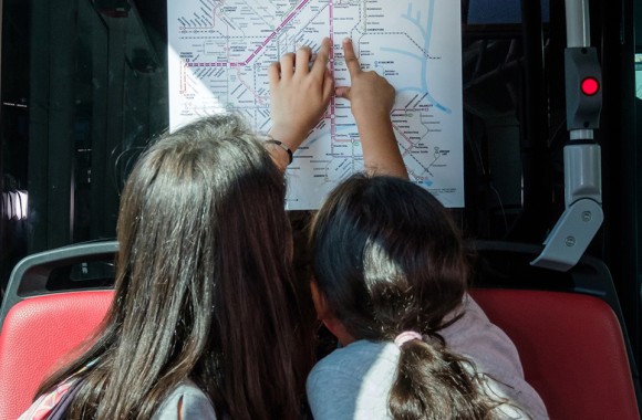 An der Offi-Rallye teilnehmende Kinder zeigen auf einen Fahrplan der LINZ AG LINIEN.