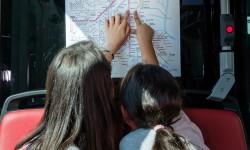 An der Offi-Rallye teilnehmende Kinder zeigen auf einen Fahrplan der LINZ AG LINIEN.