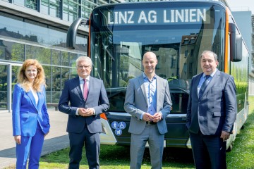 vier Personen stehen vor einem LINZ AG LINIEN Bus