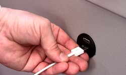 Hand steckt Ladekabel in den USB-Anschluss, welcher in den neuesten E-Autobussen vorzufinden ist