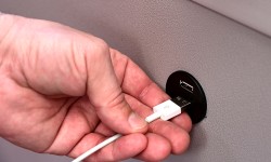 Hand steckt Ladekabel in den USB-Anschluss, welcher in den neuesten E-Autobussen vorzufinden ist