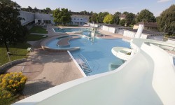 Freibadanlage der Wellnessoase Hummelhof von oben. Verschiedene Becken und Rutsche ist zu sehen