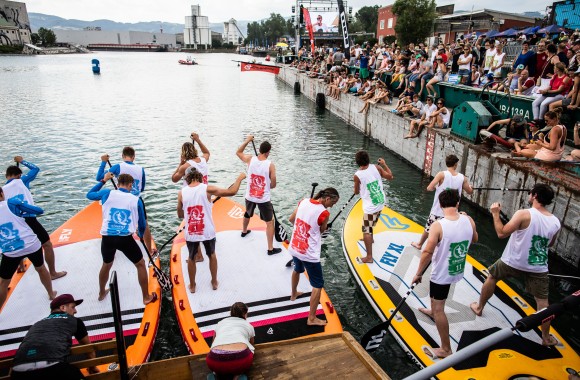 Ein Bild von den Bubble Days im LINZ AG Hafen. Menschen auf Booten im Wasser und rechts davon Zuschauer.