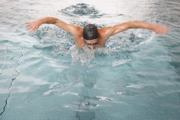 Schwimmer mit Schwimmbrille -und haube schwimmt im Sportbecken Hummelhof