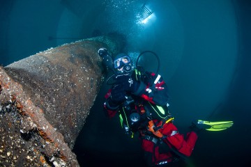 Unterwasseraufnahme in Froschperspektive von Taucher mit Atmungsgerät im Faulturm