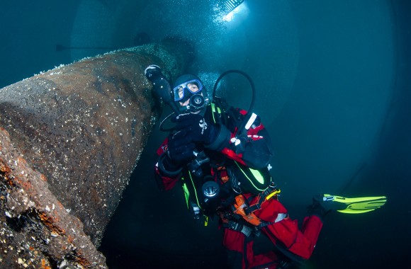 Unterwasseraufnahme in Froschperspektive von Taucher mit Atmungsgerät im Faulturm