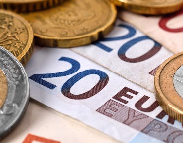 Euromünzen liegen auf Euroscheinen.