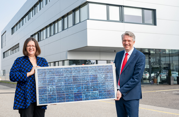 Ein Mann und eine Frau halten eine Photovoltaikanlage in der Hand.