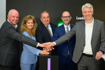 Die Personen Markus Past, Jutta Rinner, Erich Haider, Dietmar Prammer und Josef Siligan stehen vor einer Werbefläche der Telekom und drücken gemeinsam auf einen roten Startknopf.