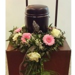 Blumenkranz mit rosa Gerbera und weißen Rosen rund um die Urne