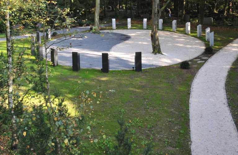 Yin-Yang Gräber in form von weißen und dunklen Steinen um einen Kieskreis aufgereiht, In der Mitte zwei Bäume