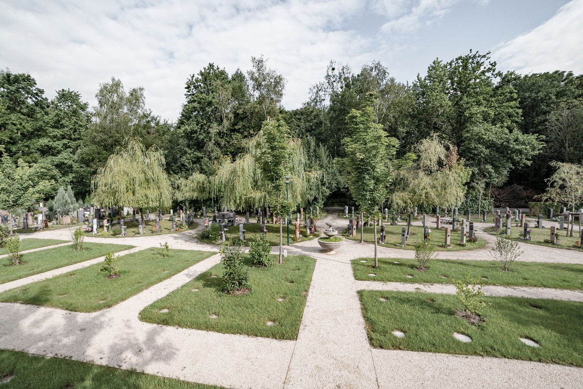 Verabschiedungshalle von außen mit rosa blühenden Kirschbäumen