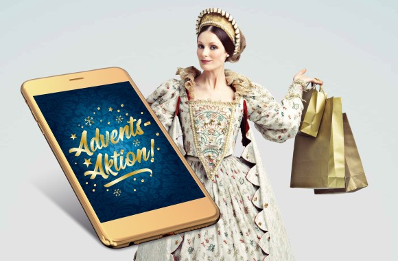 Königin mit Shoppingtaschen in der Hand. Vor ihr befindet sich ein Smartphone mit "Adventsaktion!"