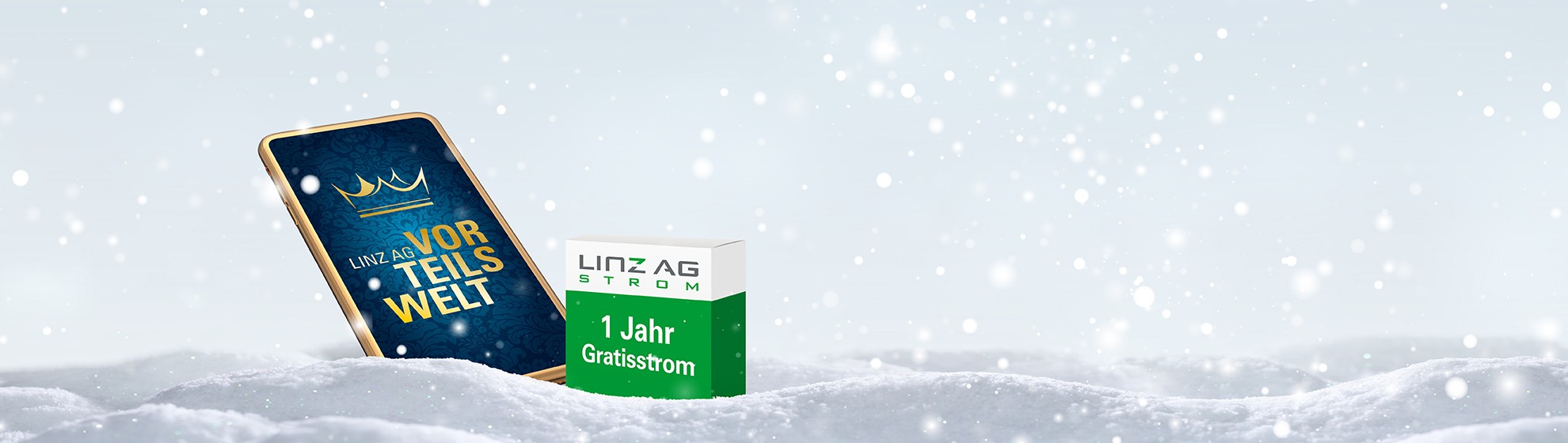 Smartphone mit Vorteilswelt-App am Display steckt im Schnee, daneben eine Schachtel mit der Aufschrift 1 Jahr Gratisstrom und Weihnachtsmütze