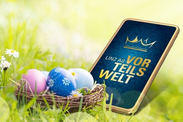 Smartphone mit Vorteilswelt Logo, daneben ein Osternest mit Ostereiern