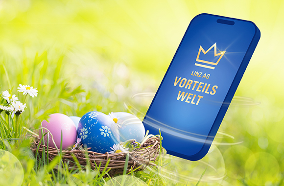 Smartphone mit Vorteilswelt Logo, daneben ein Osternest mit Ostereiern