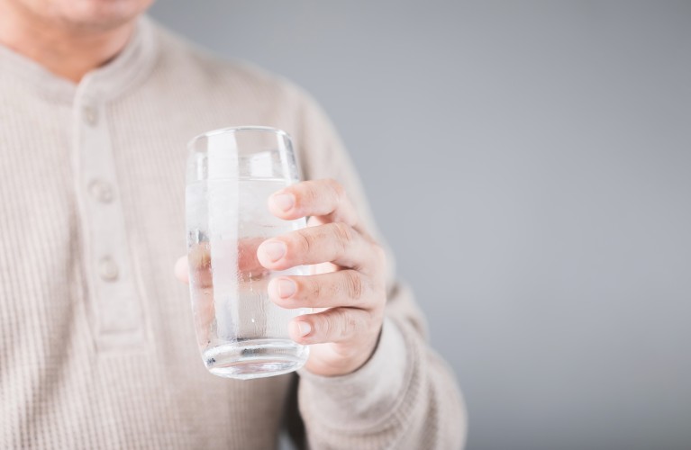 Mann hält Glas mit Wasser in der Hand