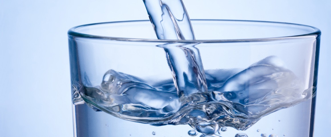 in ein Wasserglas wird Wasser eingefüllt
