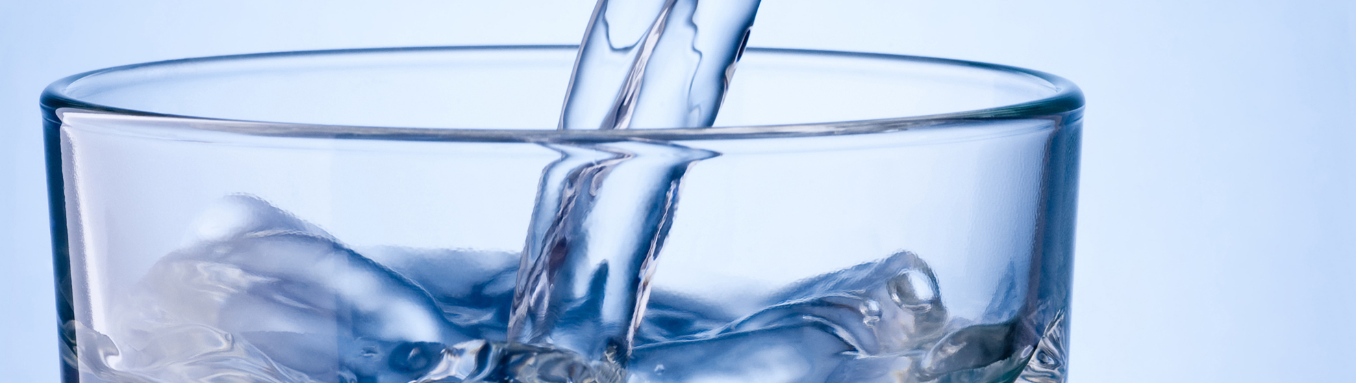in ein Wasserglas wird Wasser eingefüllt